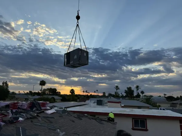 A photo of a crane lifting an HVAC unit into place