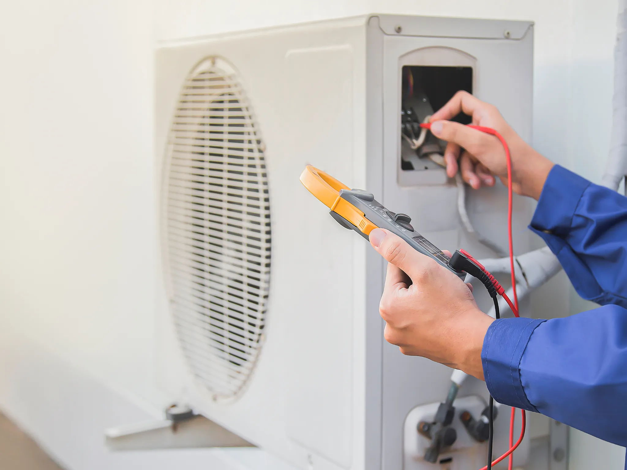 A photo of a technician working on a rooftop HVAC unit.