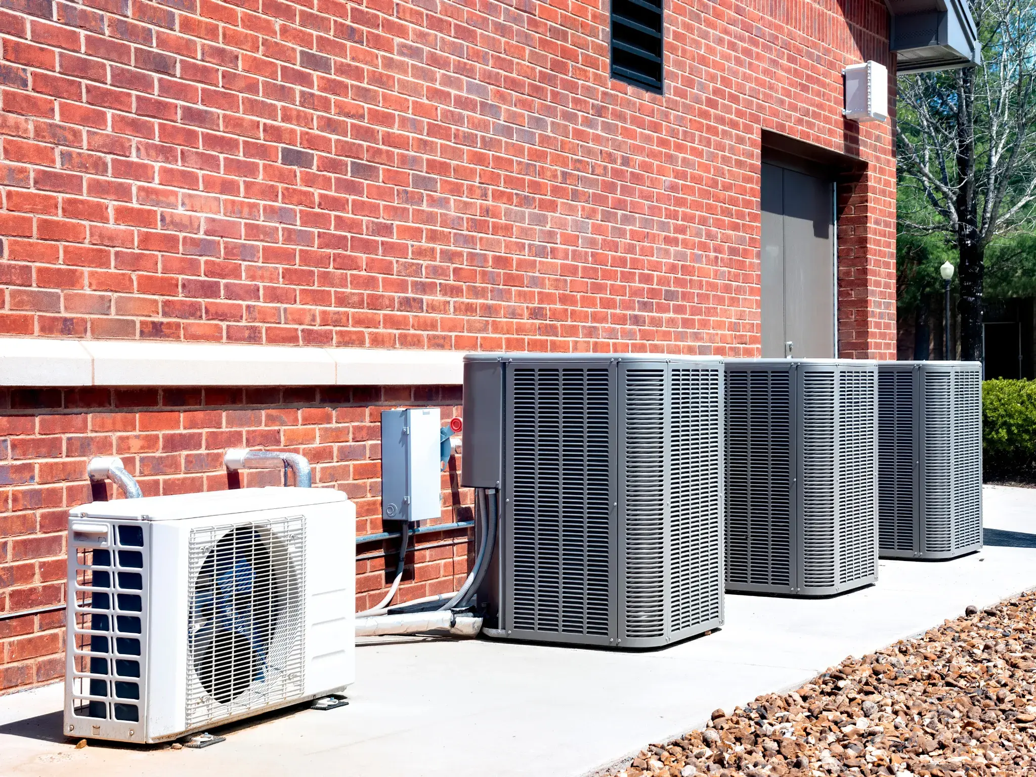 A photo of HVAC units in a row outside an apartment complex